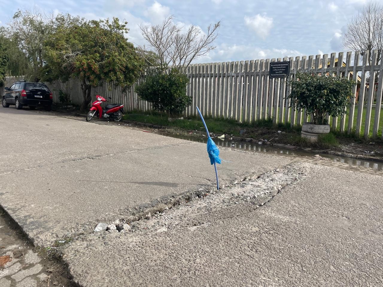 Asfalto cedendo: moradores do bairro Navegantes fazem sinalização com plástico e mangueira