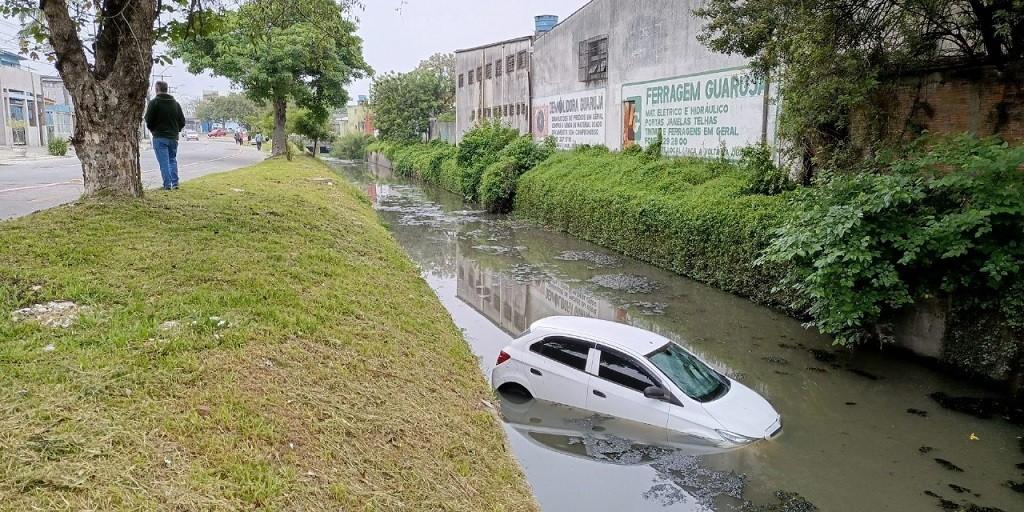 Carro desliza e cai no Canal do Pepino após colisão na avenida Juscelino Kubitschek